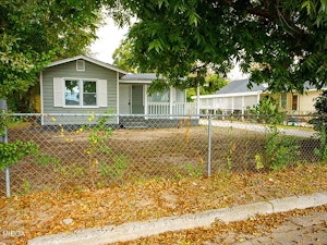 Single-family home with a spacious front yard, mature trees, and a quiet residential setting.