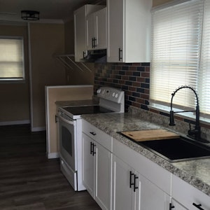 Practical kitchen featuring classic wooden cabinetry, generous counter space, and natural light—perfect for daily cooking.