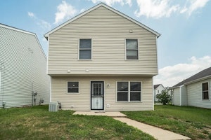 Two-story home with durable siding, large rear windows providing natural light, and a private backyard space.