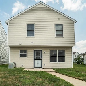 Two-story home with durable siding, large rear windows providing natural light, and a private backyard space.